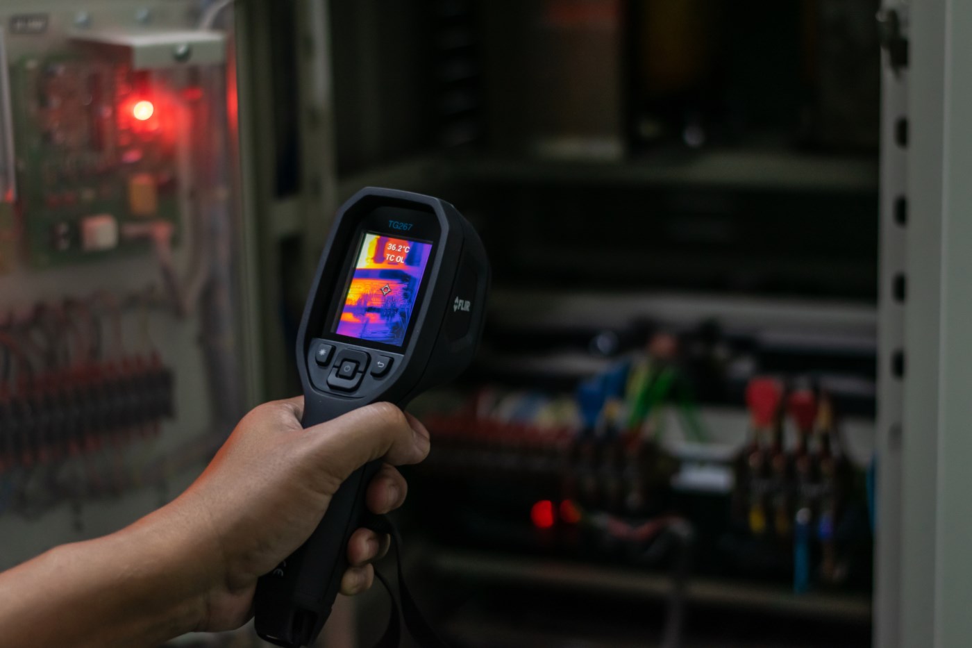Elektriker som bruker et varmesøkende kamera for å finne varme punkter i et el-anlegg